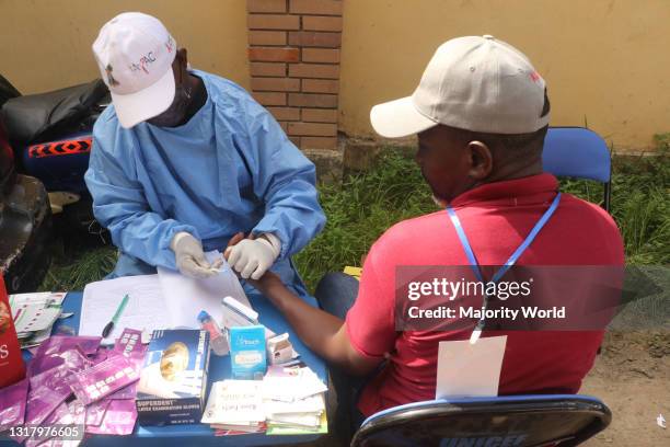 Health worker takes the blood sample of a Lagos state waste bin worker for an HIV/AIDS test on International Workers Day. International Workers Day...