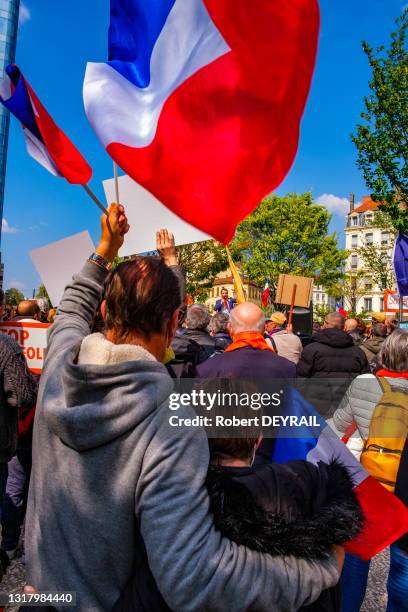 Un jeune couple de militants sous un drapeau français lors du rassemblement "anti-confinement" contre les masques, pour la chloroquine et le "Frexit"...