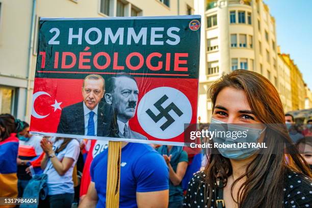 Une jeune femme porte une pancarte avec les photos de Erdogan, Hitler et une croix gammée avec le texte "2 HOMMES 1 IDÉOLOGIE" lors de la journée de...