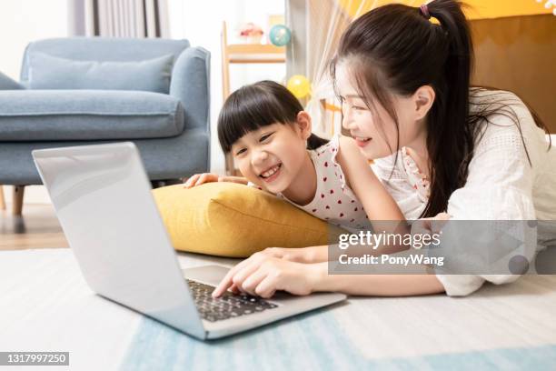 mother and daughter watch cartoon - film benefit stock pictures, royalty-free photos & images