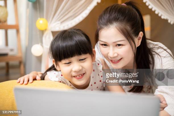 mother and daughter watch cartoon - film benefit stock pictures, royalty-free photos & images
