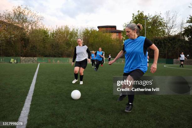 women compete in a football match - senior kicking stock pictures, royalty-free photos & images