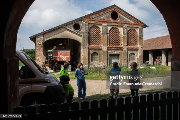 Nurse and two volunteers of the Italian Civil Protection talk to a farmer in front of his farm as they take part in a door-to-door COVID-19 vaccine...