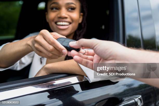 frau lächelt, wenn sie schlüssel zu neuem auto erhält - car ownership stock-fotos und bilder