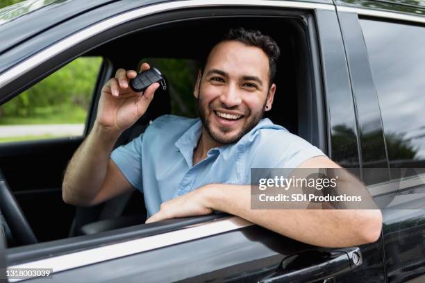 man smiles broadly from driver's seat after buying new car - buying a car stock pictures, royalty-free photos & images