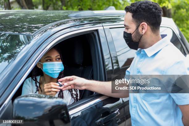 woman receives keys for new car from salesman - park service stock pictures, royalty-free photos & images