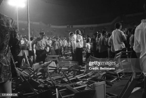 Young people are led from the scene at Singer Bowl after a disturbance erupted during a performance by the band "The Doors." Dozens of people charged...