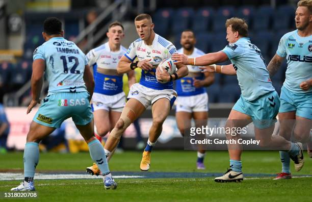 Ash Handley of Leeds is tackled by Eddie Battye of Wakefield during the Betfred Super League match between Leeds Rhinos and Wakefield Trinity at...