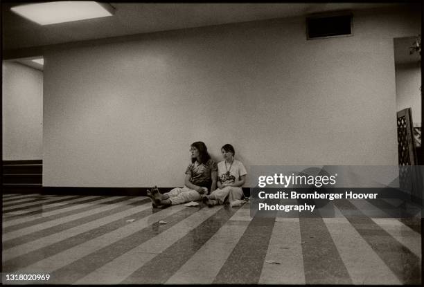 View of a young couple as they sit together on a concourse floor at Bill Graham Auditorium, San Francisco, California, January 28, 1987. They were...