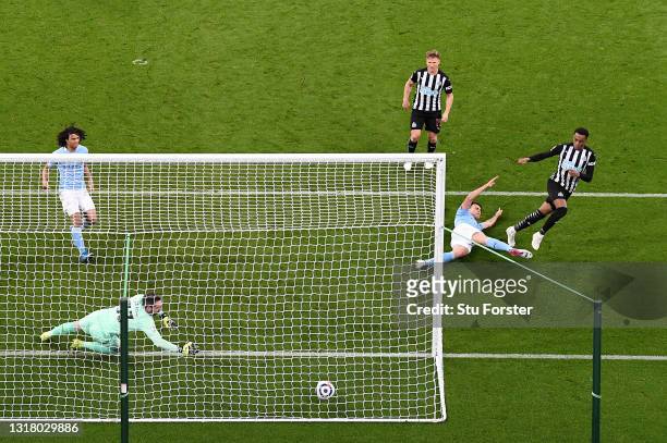 Joe Willock of Newcastle United scores their side's third goal past Scott Carson of Manchester City whilst under pressure from Eric Garcia of...
