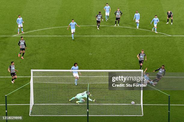 Joe Willock of Newcastle United scores their side's third goal past Scott Carson of Manchester City whilst under pressure from Eric Garcia of...