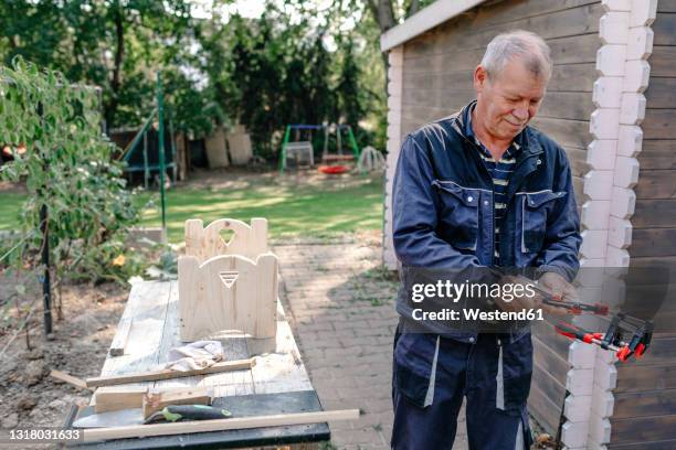 senior man doing carpentry work in backyard - bar clamp stock pictures, royalty-free photos & images