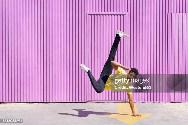 man doing handstand on footpath during sunny day - man with arrow stock pictures, royalty-free photos & images