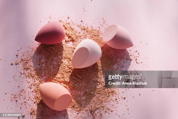 colorful pink and red sponges for make up on pink background. face powder. - make up powder stockfoto's en -beelden