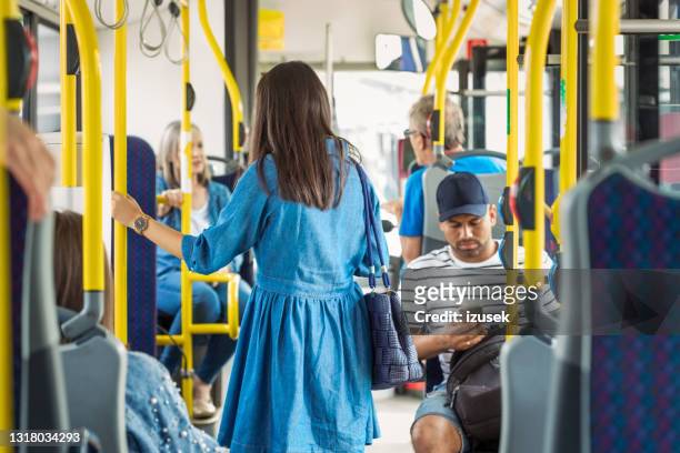 fahrgäste pendeln im bus - bus interior stock-fotos und bilder