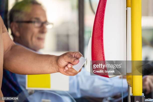 mann zahlt fahrpreis per smartcard im bus - fahrpreis stock-fotos und bilder