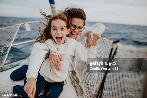 laughing mother with excited daughter on sailboat during vacation - kid sailing imagens e fotografias de stock