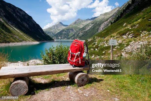 backpack on wooden bench during sunny day at zillertal, austria - wooden bench stock pictures, royalty-free photos & images