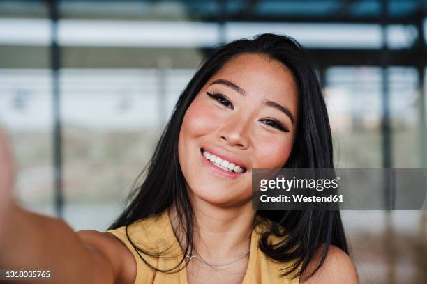 female professional taking selfie at office - selfie stockfoto's en -beelden