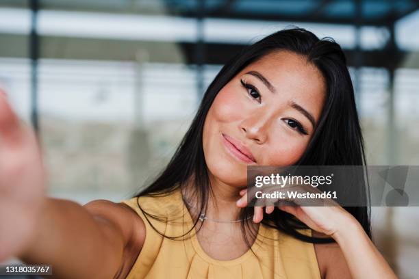 female entrepreneur taking selfie at office - hoofd schuin stockfoto's en -beelden