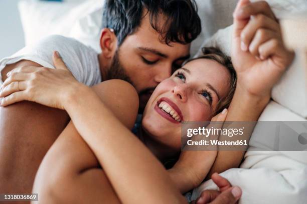 young romantic couple lying on bed at home - innamorarsi foto e immagini stock