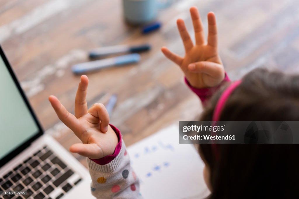 Girl counting fingers while studying at home