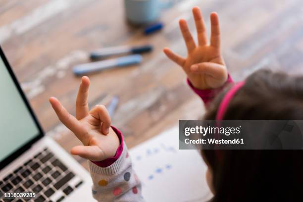 girl counting fingers while studying at home - count stockfoto's en -beelden