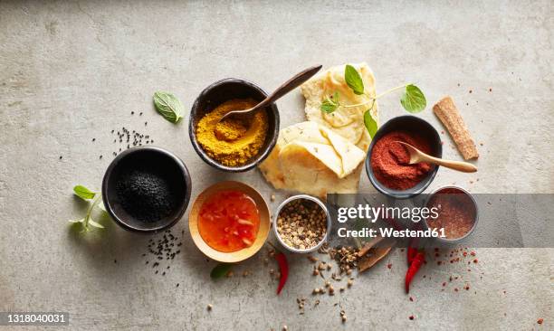 studio shot of naan bread, chili dipping sauce and bowls with various masala spices - garam masala stock pictures, royalty-free photos & images