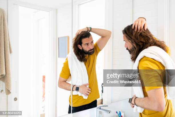 man with head in hand looking at mirror - haare mann stock-fotos und bilder
