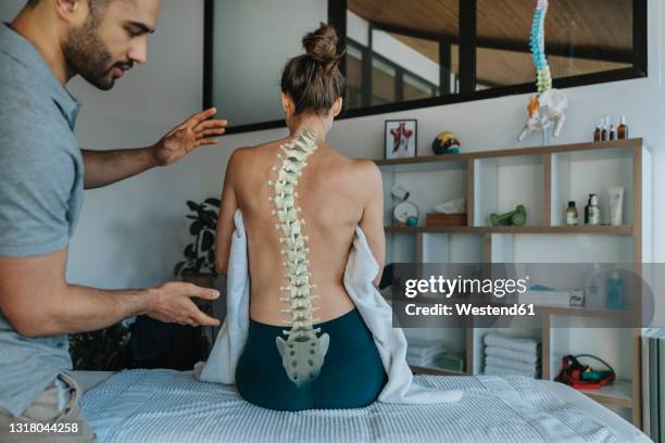 physiotherapist looking at female patient's bent spine - skolios bildbanksfoton och bilder