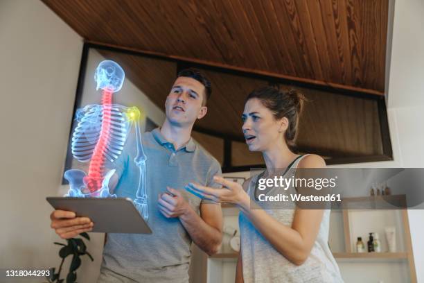 physiotherapist showing cause of pain in the shoulder joint to female patient - shoulder anatomy stock pictures, royalty-free photos & images