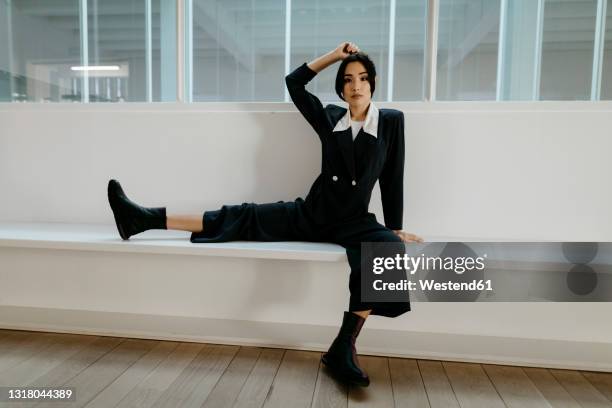 woman sitting with legs apart on white seat - legs spread fotografías e imágenes de stock