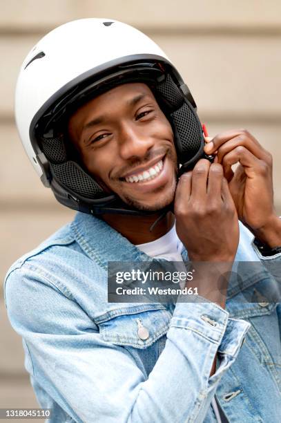 african man wearing crash helmet - crash helmet stock pictures, royalty-free photos & images