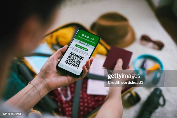 junge frau mit digitalen pass-app auf handy für reisen während covid-19 - immunisation certificate stock-fotos und bilder