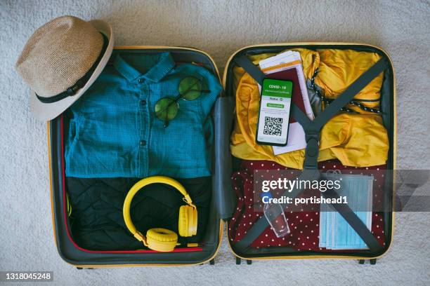 packing for trip and digital international certificate of covid-19 vaccination - summer travel bag stock pictures, royalty-free photos & images