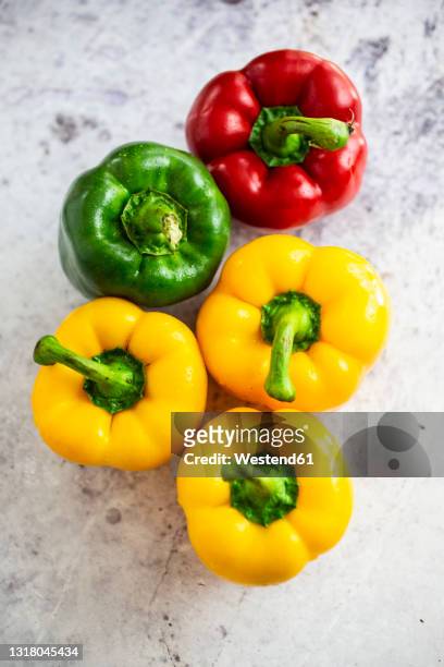 studio shot of red, green and yellow bell peppers - red bell pepper fotografías e imágenes de stock