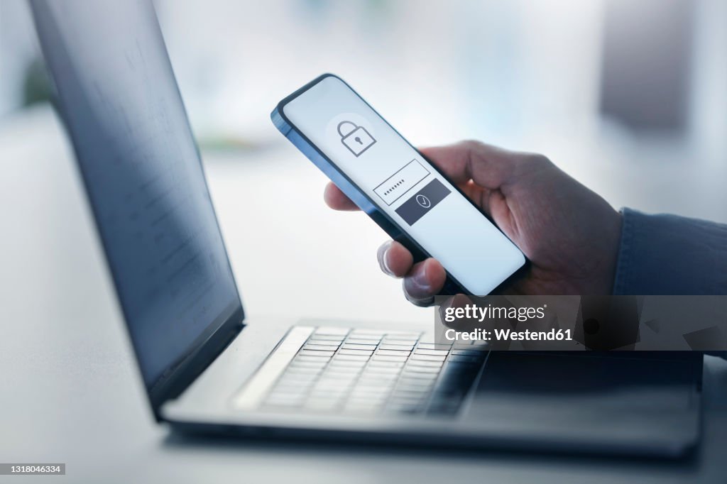 Man holding smart phone with data security on display at office