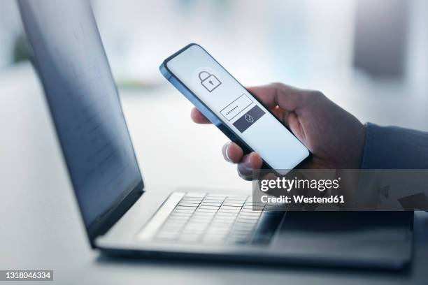 man holding smart phone with data security on display at office - firewall stock pictures, royalty-free photos & images