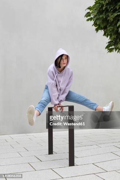girl jumping over metal by wall - balancieren mauer stock-fotos und bilder