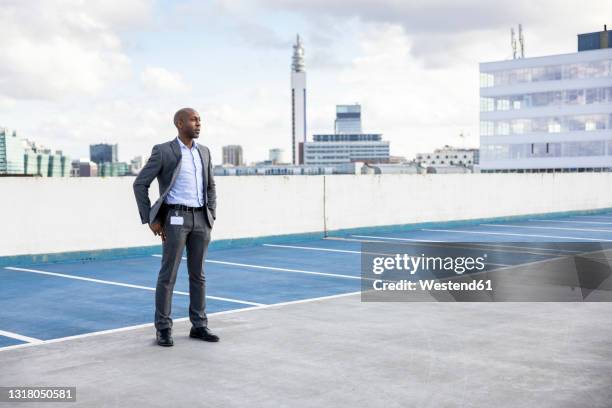 male professional in suit standing at terrace parking - businessman in black suit photos et images de collection