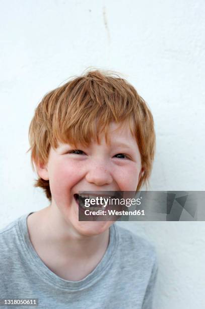laughing redhead boy in front of white wall - 7 stock-fotos und bilder
