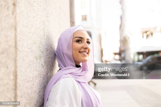 beautiful teenage girl in hijab looking away while standing by wall in city - beautiful arab girl 個照片及圖片檔