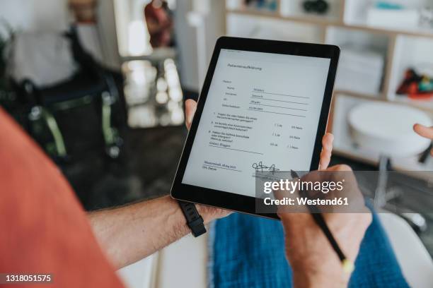 male patient digitally signing form in practice - autograph stock-fotos und bilder