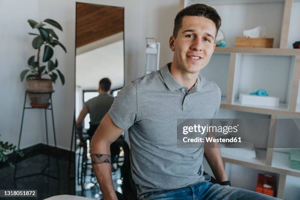 young man sitting on wheelchair in medical practice - man in wheelchair stock pictures, royalty-free photos & images