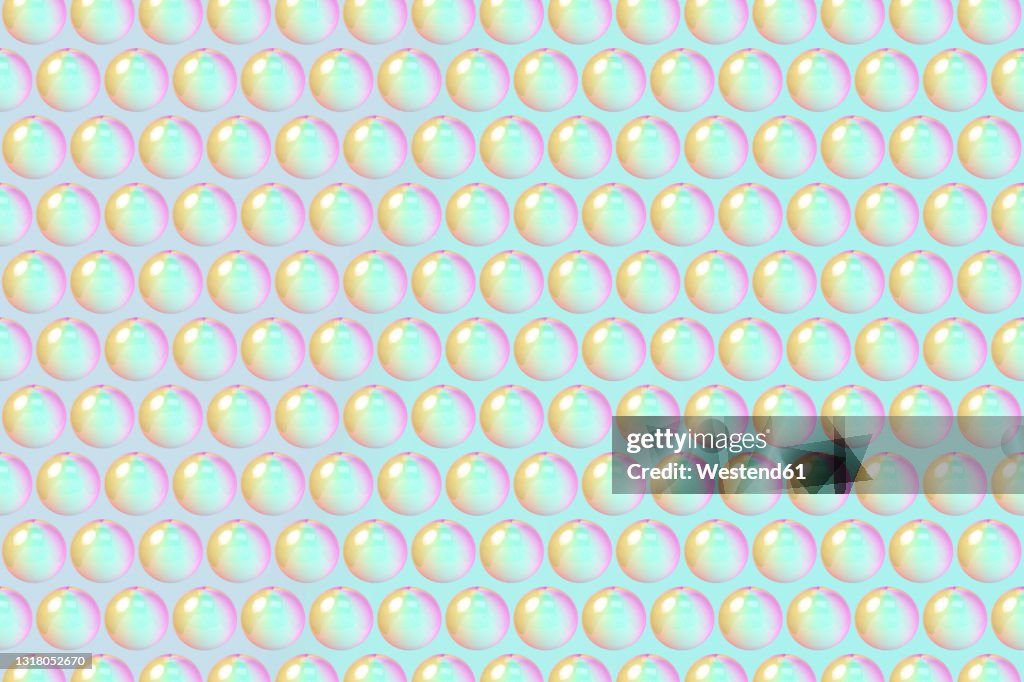 Three dimensional pattern of rows of bubbles against green background