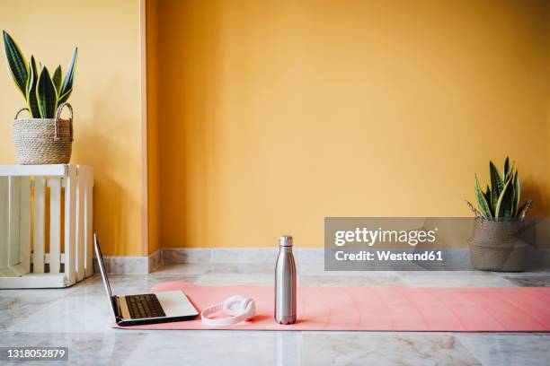 laptop, water bottle and headphones on exercise mat at home - tatame equipamento para exercícios - fotografias e filmes do acervo