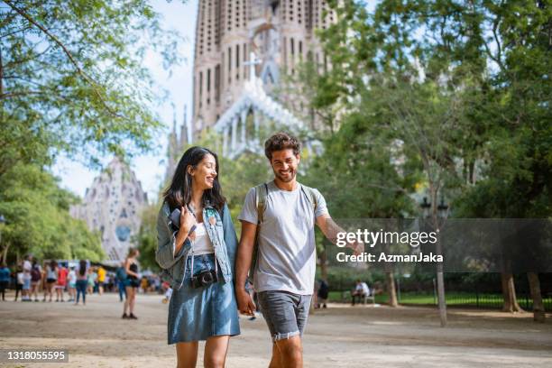 vacationing couple walking through barcelona public park - sagrada família imagens e fotografias de stock