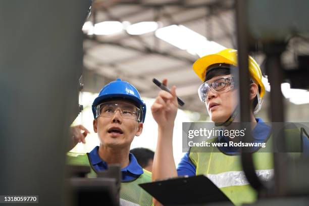 technician workers checking a control panel monitor of machinery in production line - kleine scherptediepte stockfoto's en -beelden