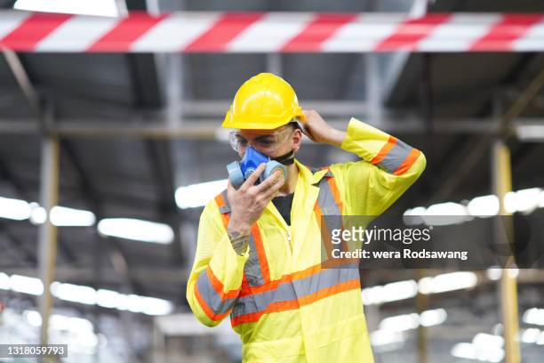 portrait of factory worker wearing safety chemical mask and protective workwear - atemschutz stock-fotos und bilder