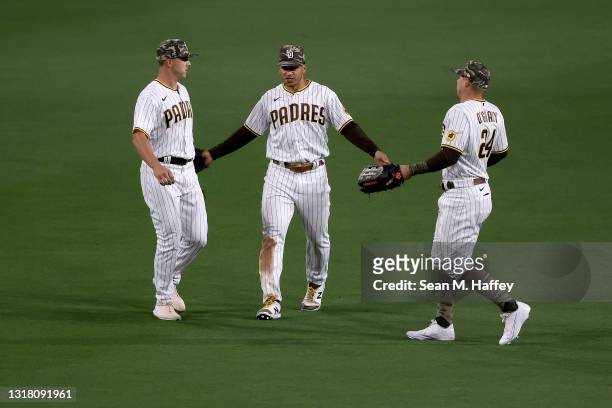 Patrick Kivlehan, Trent Grisham, and Brian O'Grady of the San Diego Padres celebrate after defeating the St. Louis Cardinals 5-4 in a game at PETCO...